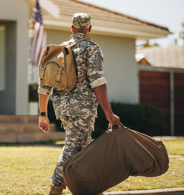 Soldier returning home with gear bag